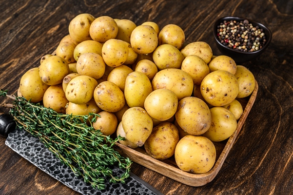 young whole baby potatoes wooden tray - Жареный картофель по-деревенски