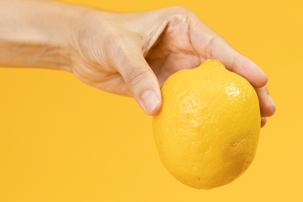 close up hand holding raw lemon - Березовый сок консервированный