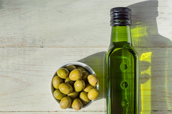 extra virgin olive oil green bottle fresh green olives wooden table - Киноа с креветками
