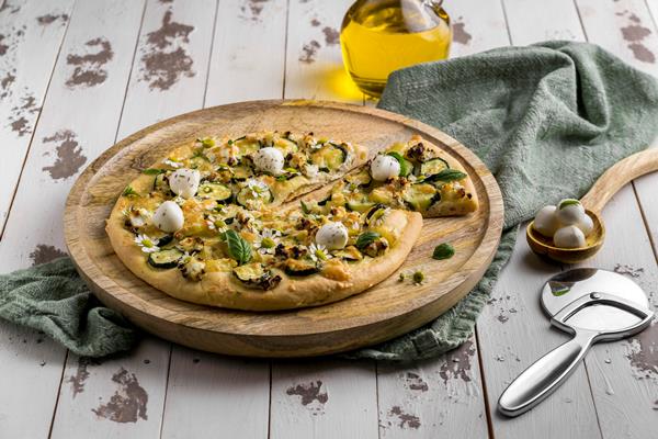 high angle delicious cooked pizza with chamomile flowers cutter - Настурция в кулинарии: соус из семян и листьев