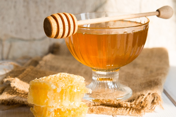 honey drips from honey dipper into beautiful glass bowl close up healthy organic thick honey combs - Хлеб с чагой