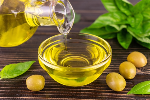 olive oil is poured into glass bowl close up - Фаршированные перцы с киноа