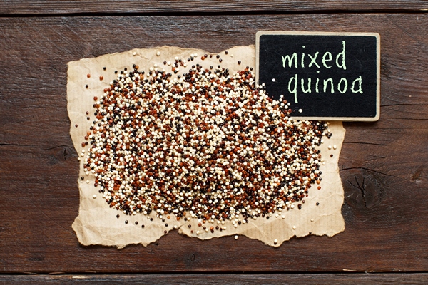 pile uncooked mixed quinoa with small chalkboard top view - Киноа в мультиварке