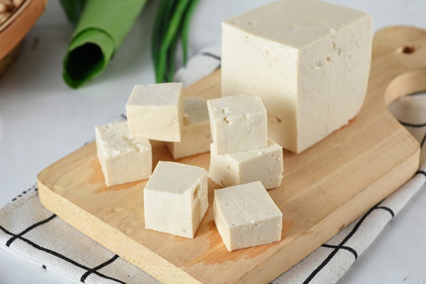 raw organic vegetarian tofu cubes wooden background - Постные сырники из тофу и банана