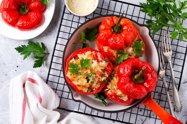 red bell peppers stuffed with rice vegetables cast iron pan gray concret background - Перцы, фаршированные овощами и креветками