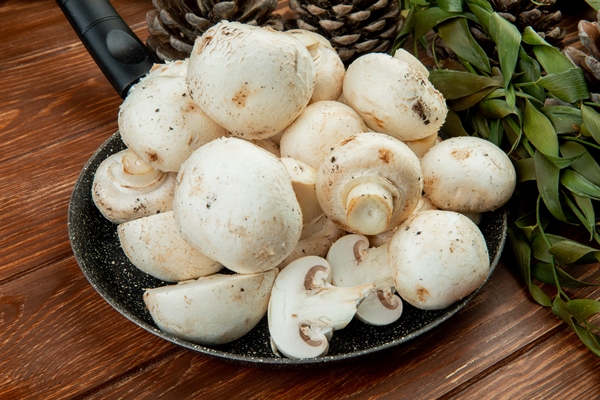 side view fresh white mushrooms frying pan wooden surface - Рисовые тефтели и семенами льна и грибами