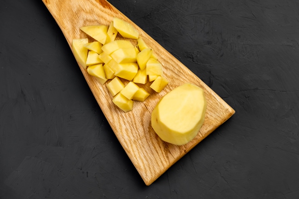 sliced raw potatoes cutting wooden board dark background preparation cooking food background recipe - Грибной суп с фунчозой
