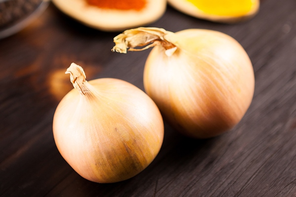 top close up view onions with different vegetables blurred background burned wooden table - Елеопита