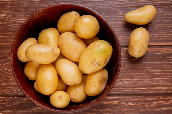 top view potatoes bowl wooden surface - Постные котлеты из сныти с картофелем