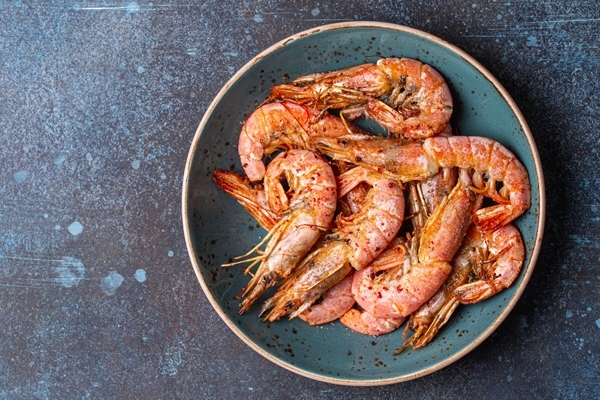 whole fried big shrimps with seasonings blue bowl stone rustic background from fresh cooked delicious grilled shrimps served plate top view healthy seafood meal space - Перцы, фаршированные овощами и креветками