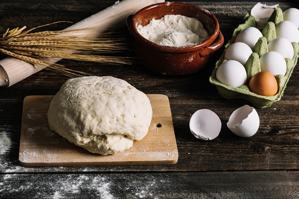 knead dough chopping board with wheat flour eggs wooden table - Тесто для хачапури на простокваше