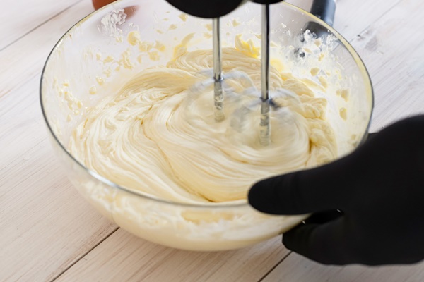 male hands mixing dough with electric mixer kitchen closeup - Ванильный пудинг из простокваши