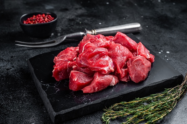 raw diced red beef meat goulash marble board black background top view - Шашлык из баранины в духовке